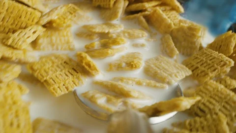 Spoon perspective of boy taking big bite of cereal while eating breakfast Vídeo Stock 127545892