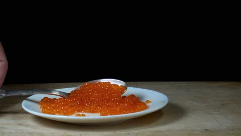A spoon picks up red caviar from a plate in 4K Stock Footage 160892208