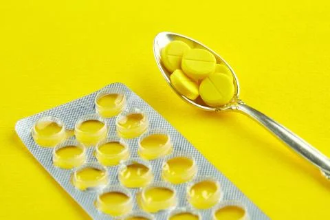 Spoon with pills and empty package of tablets Stock Photos
