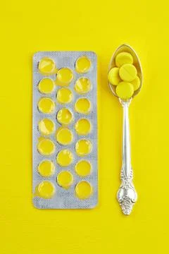 Spoon with pills and empty package of tablets Stock Photos