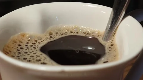 Spoon placed in a white coffee mug with hot coffee Vidéo 310408467