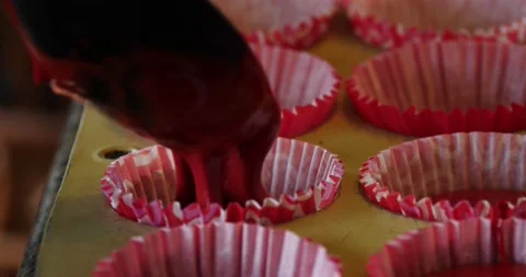 Spoon placing cupcake mix into cupcake pan close up Stock Footage 208304368