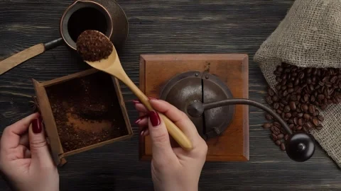 A spoon pours freshly ground coffee into a Turk for making coffee. Close-up Video stock 295656912