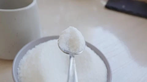 Spoon puts sugar into mug. POV. Crafting sweetness with a delicate sugar spoon 库存影片 329939191