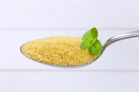 Spoon of raw couscous Stock Photos