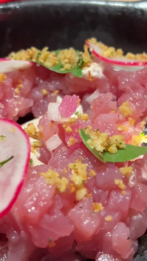 Spoon raw tuna salad from a black plate Fresh raw Tuna salad with mango, cheese Stock Footage 293514640