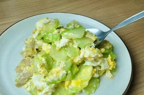 Spoon scooping Angled Luffa with Egg, Vitamin C-Rich Stock Photos
