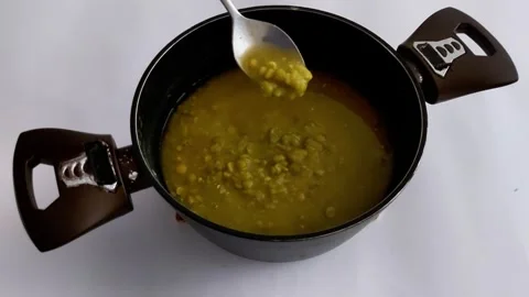 Spoon Scooping Boiled Green Peas from Saucepan on White Surface Stock Footage 324947485