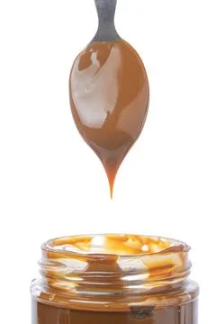 Spoon scooping dulce de leche out of a jar, traditional sweet from Argentina. Stock Photos
