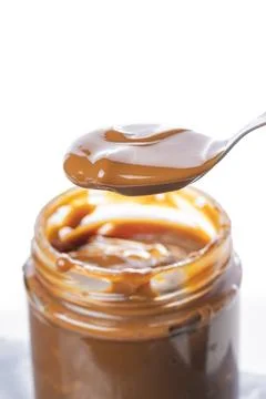 Spoon scooping dulce de leche out of a jar, traditional sweet from Argentin.. 스톡 사진