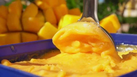 The spoon is scooping frozen mango ice-cream gelato Stock Footage 149106280