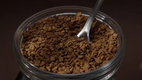 Spoon scooping granules from a jar of instant coffee Stock Footage 285489563