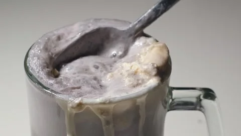 Spoon scooping grape soda float foam and ice cream in slow motion Stock Footage 345367022