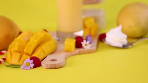 Spoon Scooping Whipped Cream Beside Fresh Mango and Smoothie Stock Footage 321325415