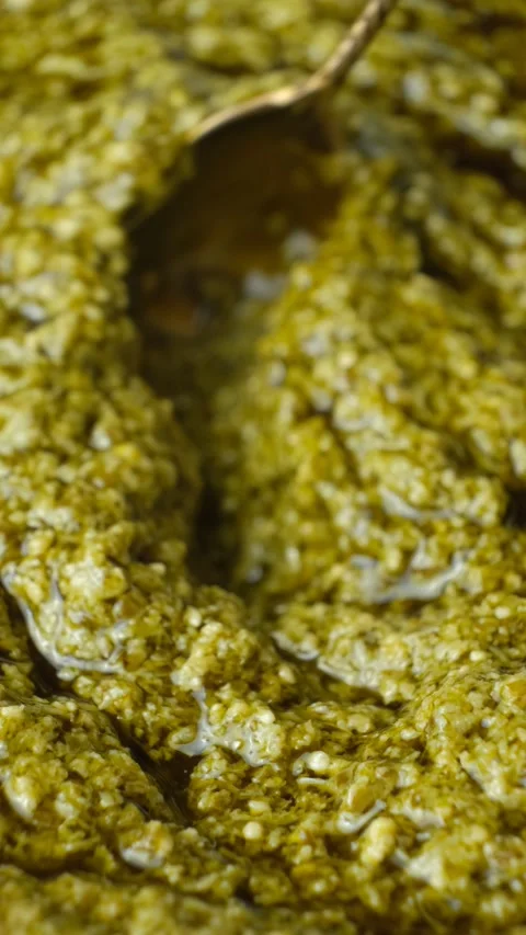 Spoon sliding through thick Italian pesto sauce with olive oil Stock Footage 337701155
