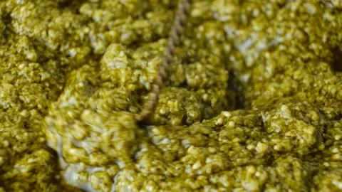 Spoon sliding through thick Italian pesto sauce with olive oil Stock Footage 337931499