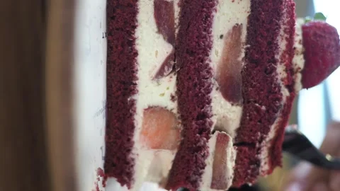 Spoon slowly taking bite of red velvet cake slice with strawberry and cream.. Stock Footage 332097097