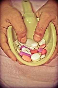 Spoon with stack of tablets in human hand Foto stock