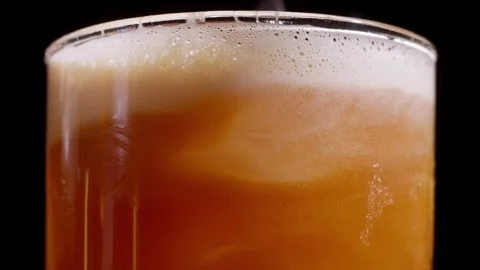 Spoon Stirring Foam into Amber Orange Cocktail in Slow Motion Stock Footage 337862509