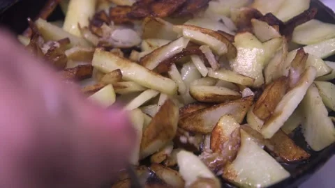 A spoon stirs potatoes with a crust in a pan, close-up Vidéo 223346700