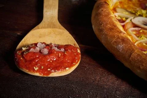 Spoon with tomato paste and pizza Stock Photos