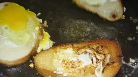 Spoon turns over pieces of egg bread in a frying pan, close-up Vídeos de archivo 233595455