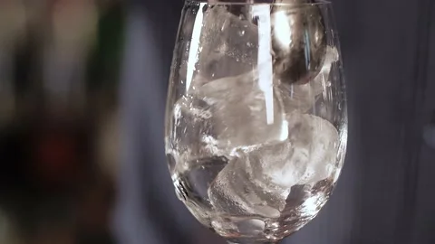 The spoon was inserted into a glass with ice cubes and began to rotate them Video stock 136217224
