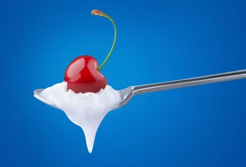 Spoon of yoghurt with cherry on top Foto stock