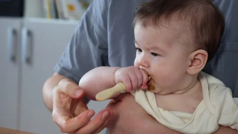 A spoonful of broccoli puree - the first taste Stock Footage 329468649