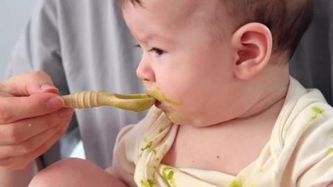 A spoonful of broccoli puree - the first taste Stock Footage 329861347