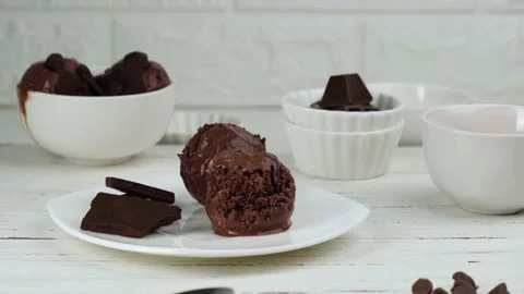 A spoonful of chocolate ice cream is put in a plate Stock Footage 156985245