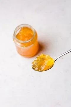 Spoonful of fruit jam with a bottle in background Stock Photos