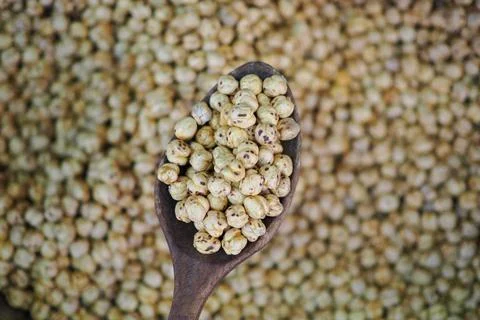 Spoonful of popped corn with a background of many popped corn pieces Stock Photos