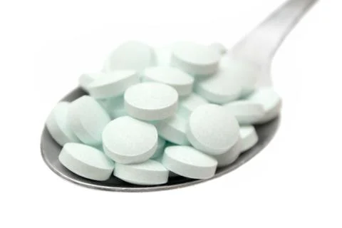 Spoonful of Tablets Isolated on a White Background Foto stock
