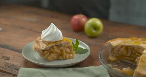 Spoonful of whipped cream on a big slice of apple pie, on a plate near the pie d Video stock 199457296