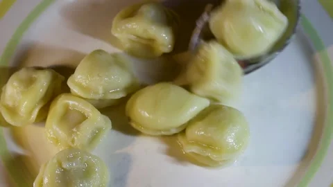 Spooning the finished dumplings onto a plate after cooking Stock Footage 331726329
