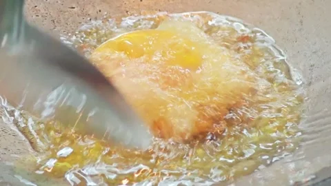 Spooning hot oil over egg yolk for Thai style crispy fried egg. Vídeo Stock 343697965