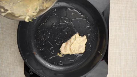 Spooning a Pale Chunky Herb Mixture into a Black Frying Pan 스톡 동영상 343303391