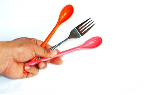 Spoons and fork in hand Stock Photos