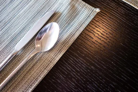 Spoons and forks on the empty dining table waiting for food to be served. Stock Photos