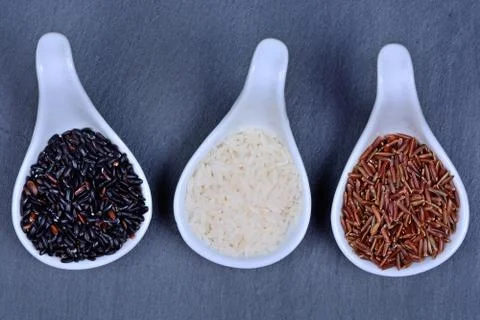 Spoons with different types of rice Stock Photos