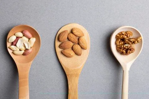Spoons with walnuts, almonds and peanut. Flat lay Stock Photos