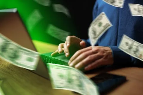 Sport bet involves using a computer to place bets while money flies around in Stock Photos