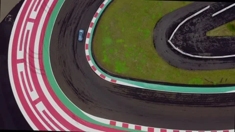 Sport car taking sharp corner on a racing track top down view drone footage Stock Footage 227339820
