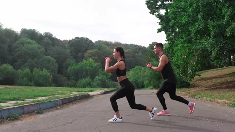 Sport couple doing lunges exercise aerial view. Fitness man and woman do lunges Stock Footage 141056859