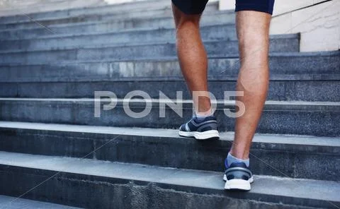 Sport, fitness and healthy lifestyle concept - man running in the city, feet Stock Photos