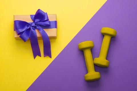 Sport flat lay composition with dumbbells and gift box Stock Photos