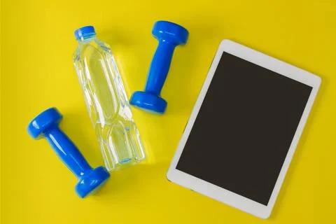 Sport flat lay composition tablet blue dumbbells bottle of water Stock Photos
