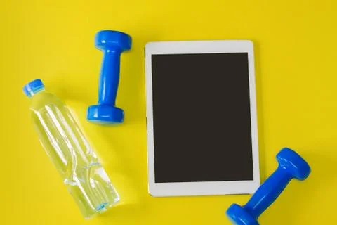 Sport flat lay composition tablet blue dumbbells bottle of water Stock Photos