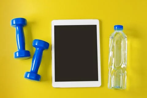 Sport flat lay composition tablet blue dumbbells bottle of water Stock Photos